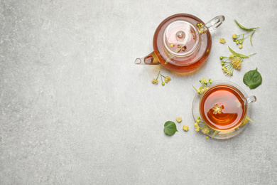 Photo of Tasty tea and linden blossom on light grey table, flat lay. Space for text