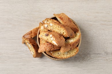 Photo of Traditional Italian almond biscuits (Cantucci) on white wooden table, flat lay