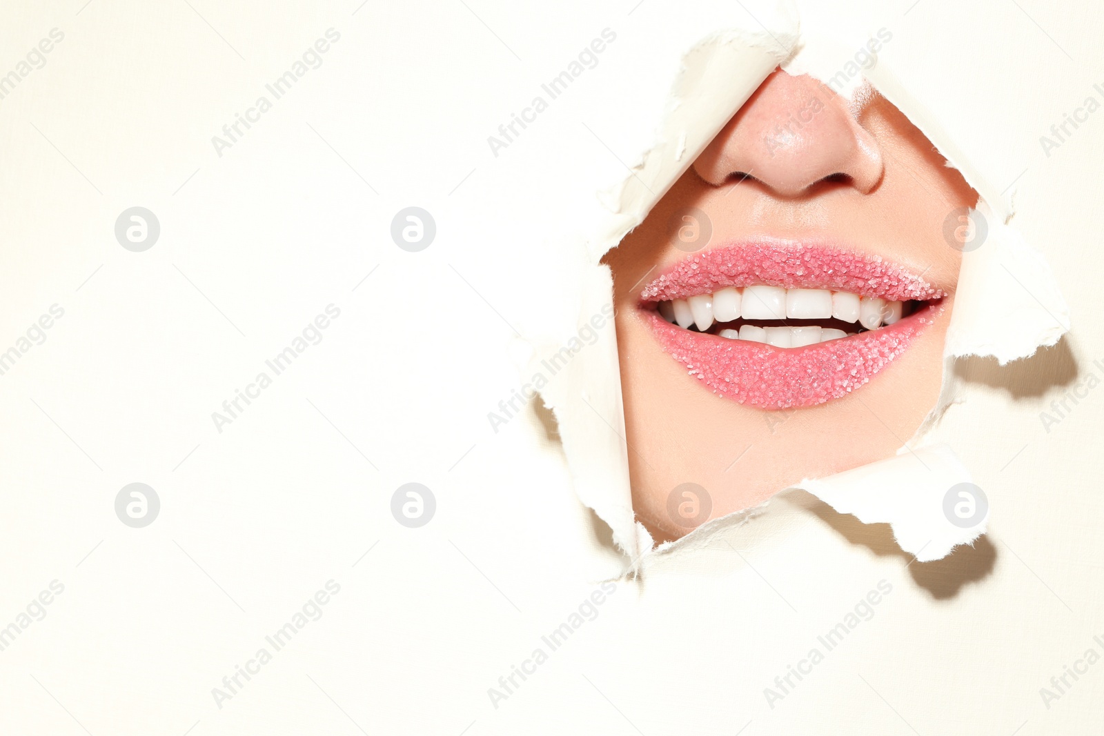 Photo of View of beautiful young woman with sugar lips through hole in color paper