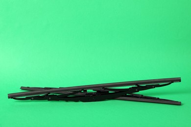 Car windshield wipers on green background. Space for text