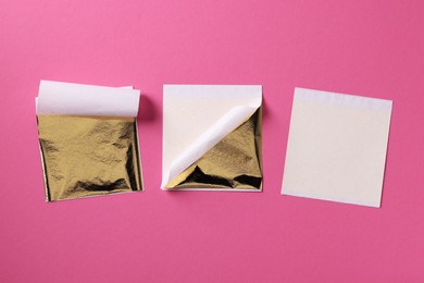 Photo of Edible gold leaf sheets on pink background, flat lay