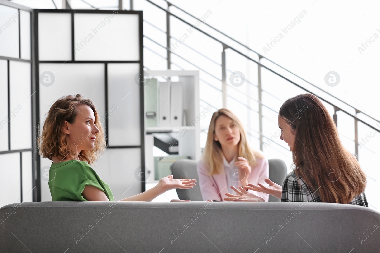 Photo of Young woman and her teenage daughter visiting child psychologist in office