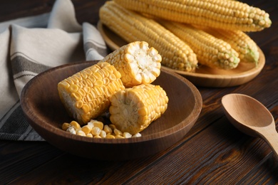 Photo of Tasty sweet corn cobs on wooden table