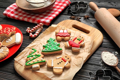 Photo of Tasty homemade Christmas cookies on black wooden table