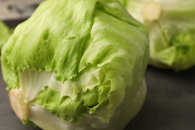 Fresh green iceberg lettuce heads and leaves on grey table, closeup