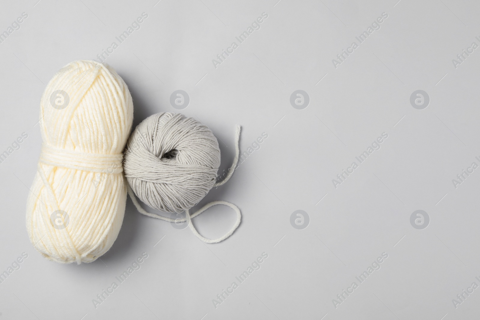 Photo of Soft woolen yarns on white background, flat lay. Space for text