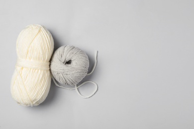 Soft woolen yarns on white background, flat lay. Space for text