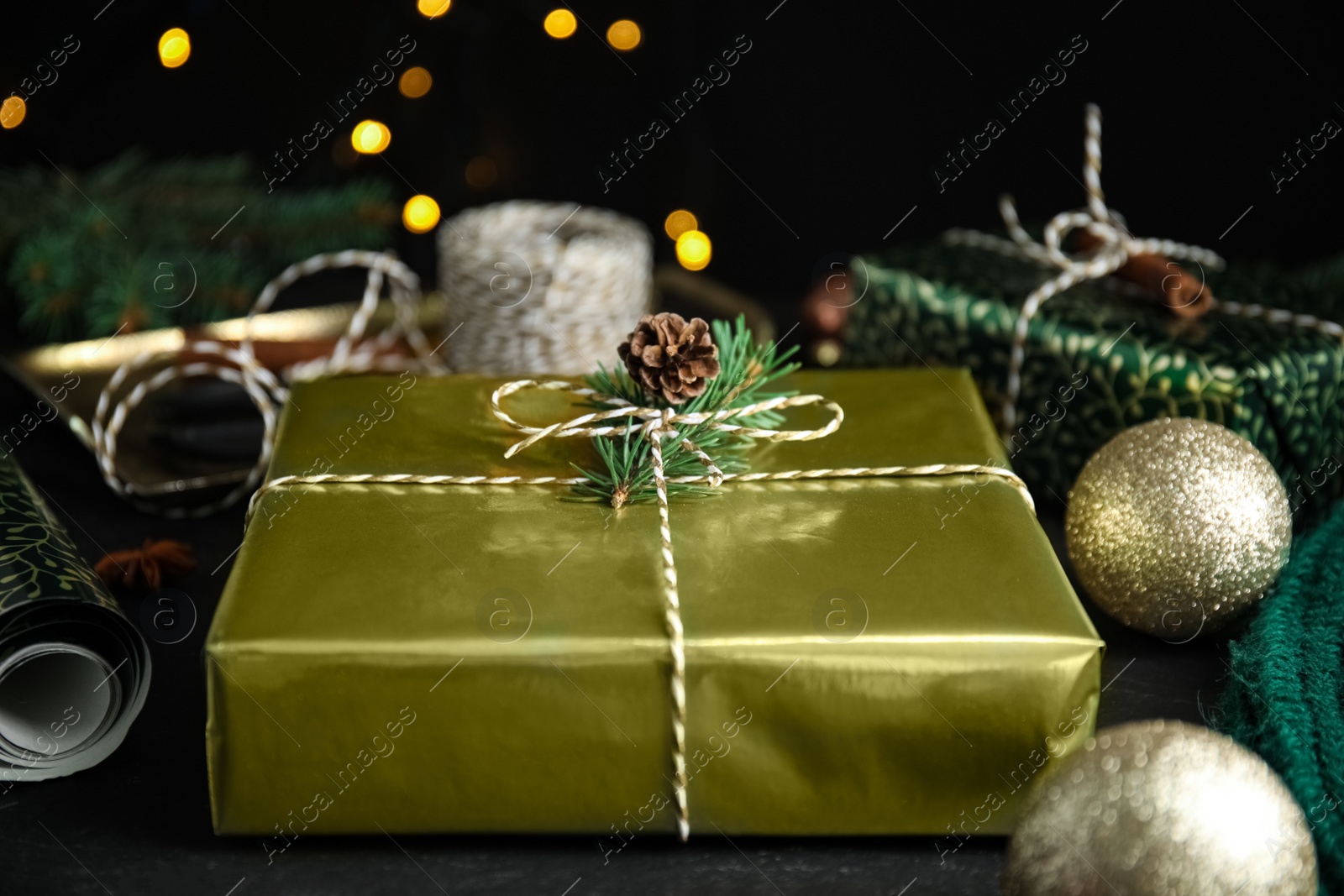 Photo of Composition with beautifully wrapped gift box on black table