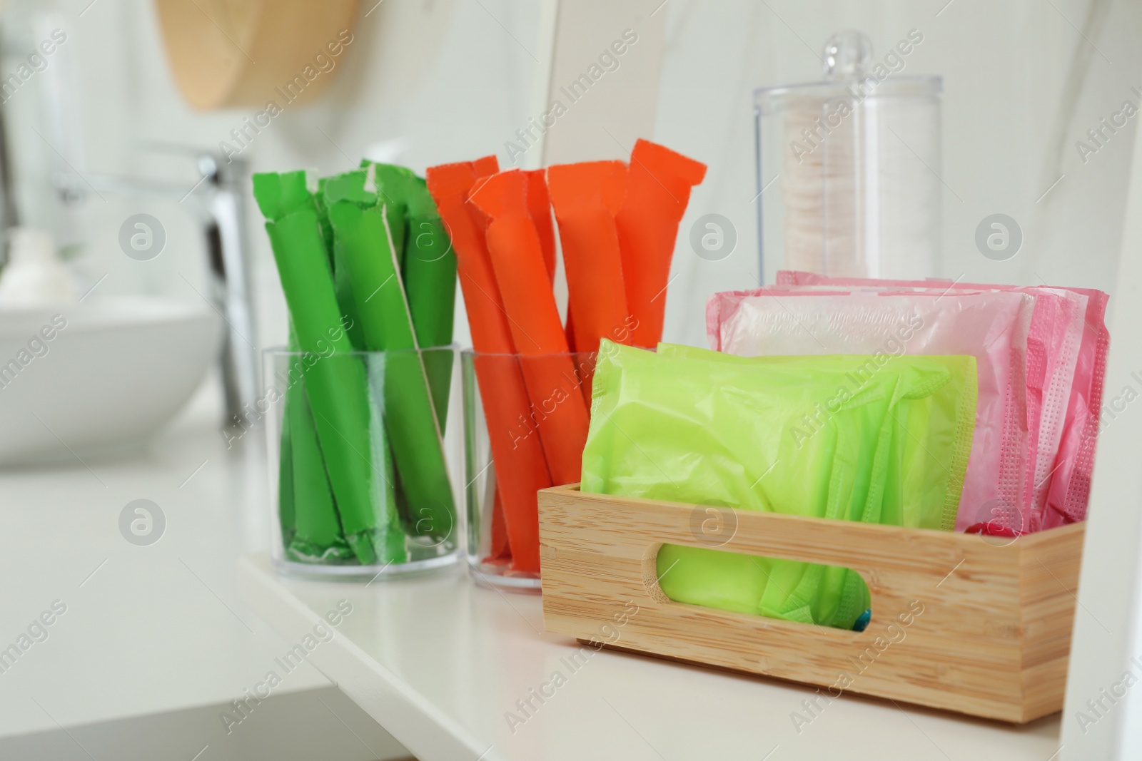 Photo of Tampons and menstrual pads on counter in bathroom. Feminine hygiene products