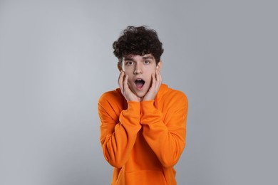 Photo of Portrait of shocked teenage boy on light grey background