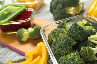 Containers with broccoli and fresh products on table, closeup. Food storage