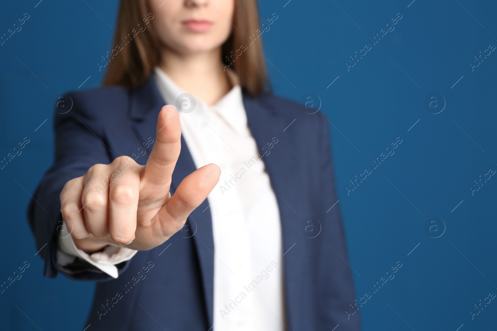 Photo of Young woman against blue background, focus on hand