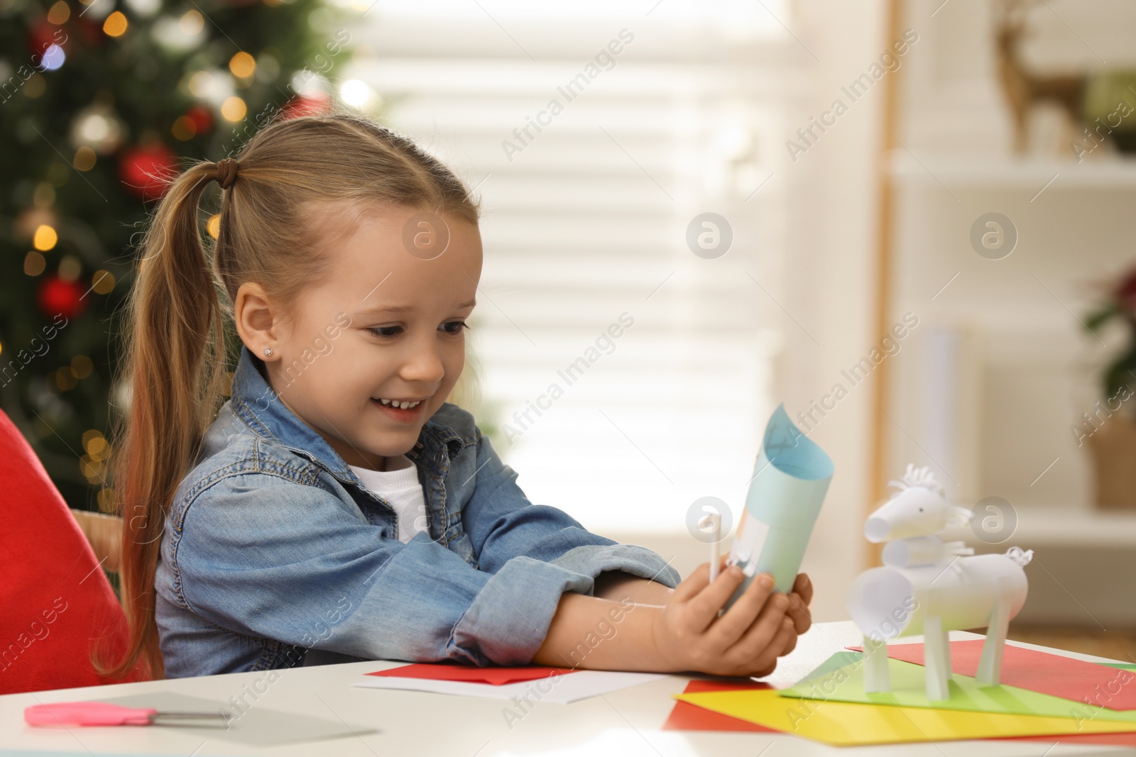 Photo of Cute little girl with paper Saint Nicholas toy at home