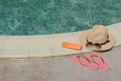 Photo of Different beach accessories near outdoor swimming pool on sunny day, space for text