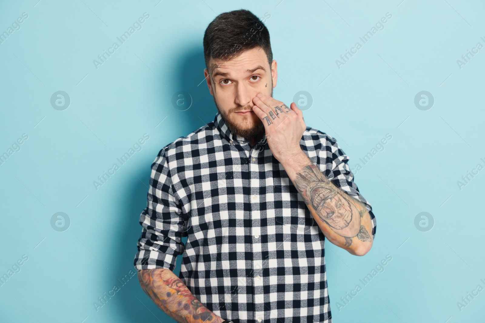 Photo of Portrait of handsome hipster man on light blue background