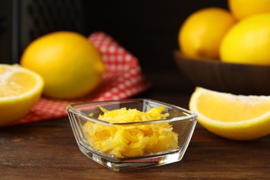 Grated lemon zest and fresh fruits on wooden table