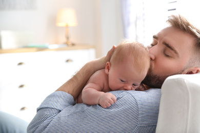 Photo of Father with his newborn son at home