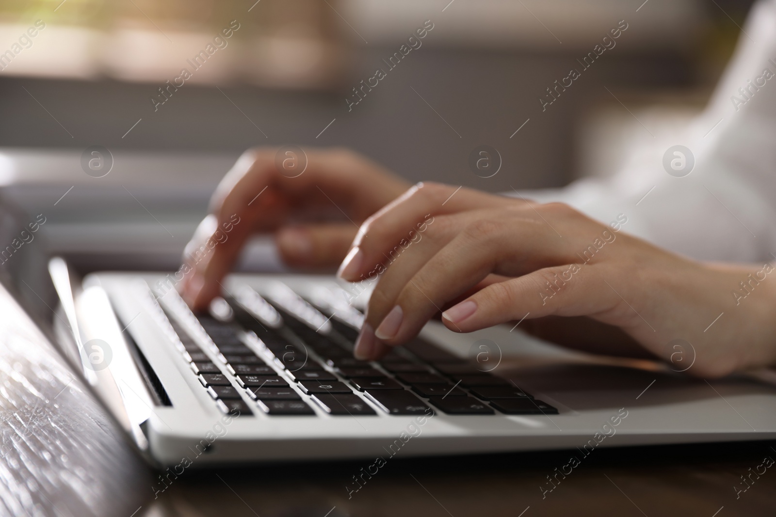 Photo of Woman working with laptop in office, closeup of hands