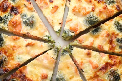 Photo of Delicious homemade quiche with salmon and broccoli on table, flat lay