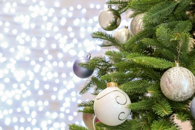 Christmas tree with festive decor against blurred fairy lights