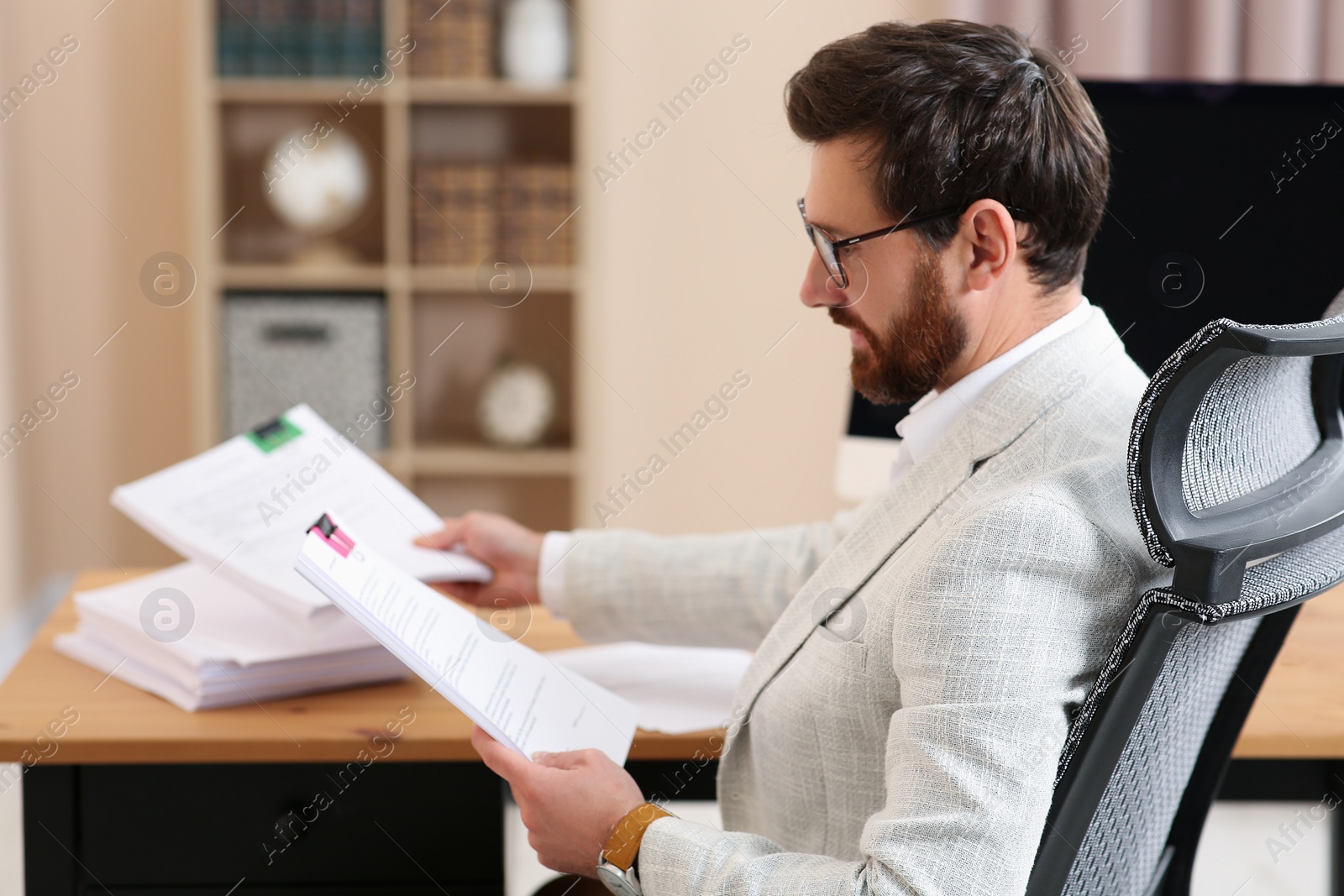 Photo of Businessman working with documents at wooden table in office