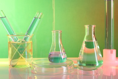 Laboratory analysis. Different glassware on table against color background