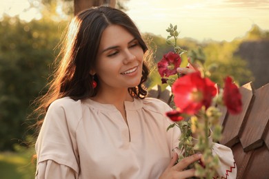 Beautiful woman in blooming garden on sunny day