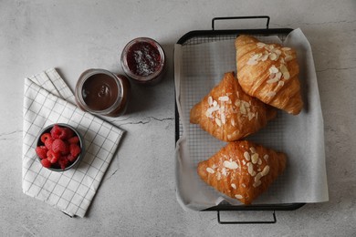 Photo of Delicious croissants served on grey table, flat lay