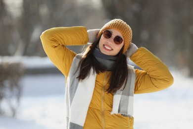 Portrait of beautiful young woman with sunglasses on winter day outdoors