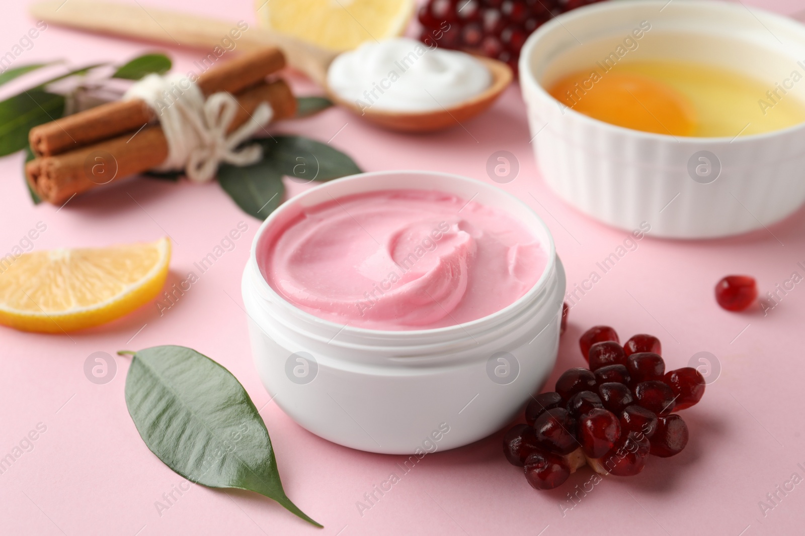 Photo of Fresh pomegranate and jar of facial mask on pink background. Natural organic cosmetics