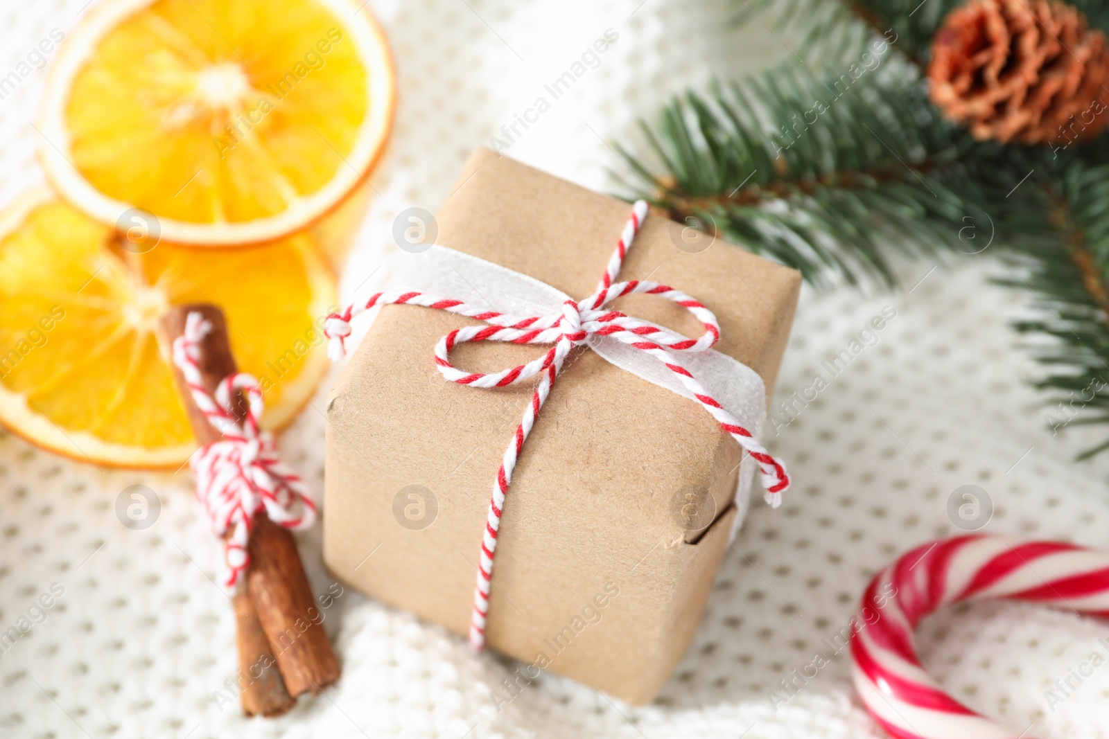 Photo of Christmas gift box and decor on white crocheted background, closeup