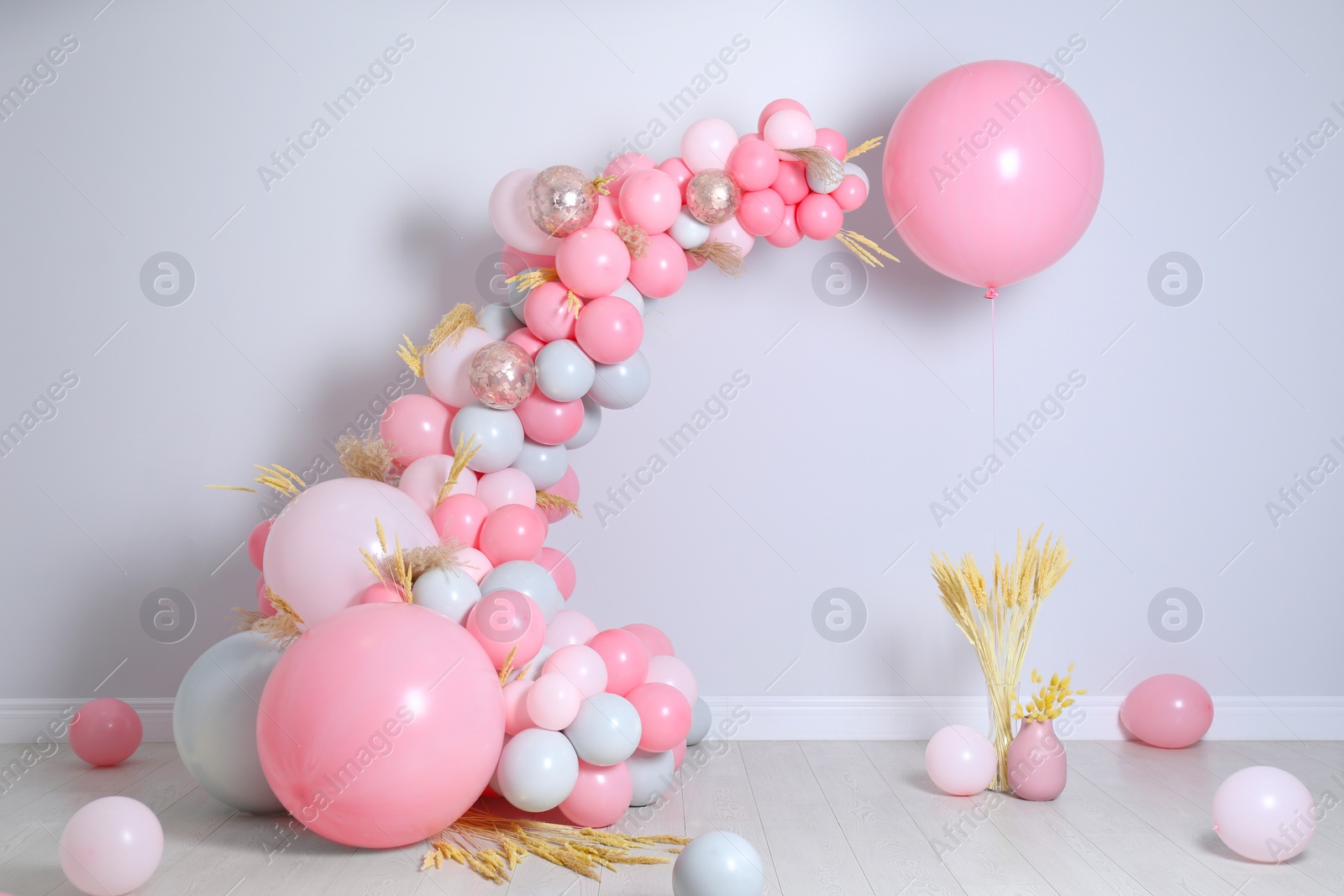 Photo of Beautiful composition with balloons and spikelets near light wall