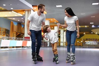 Happy family spending time at roller skating rink