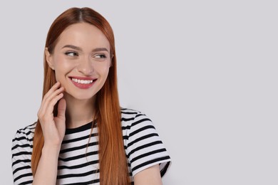 Portrait of beautiful young woman on light gray background, space for text