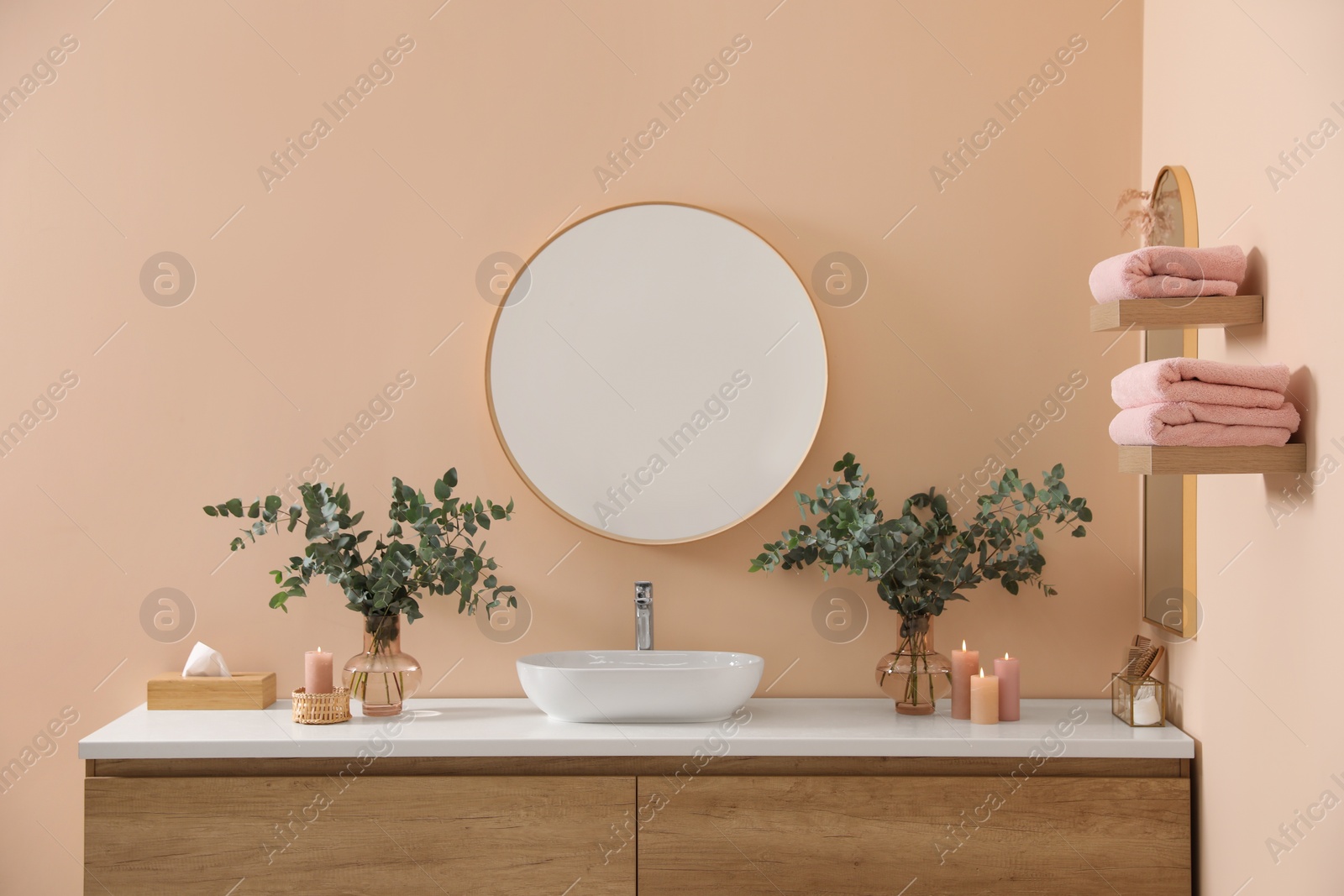 Photo of Stylish mirror, eucalyptus branches and vessel sink in modern bathroom. Interior design