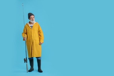 Photo of Fisherman with fishing rod on light blue background, space for text