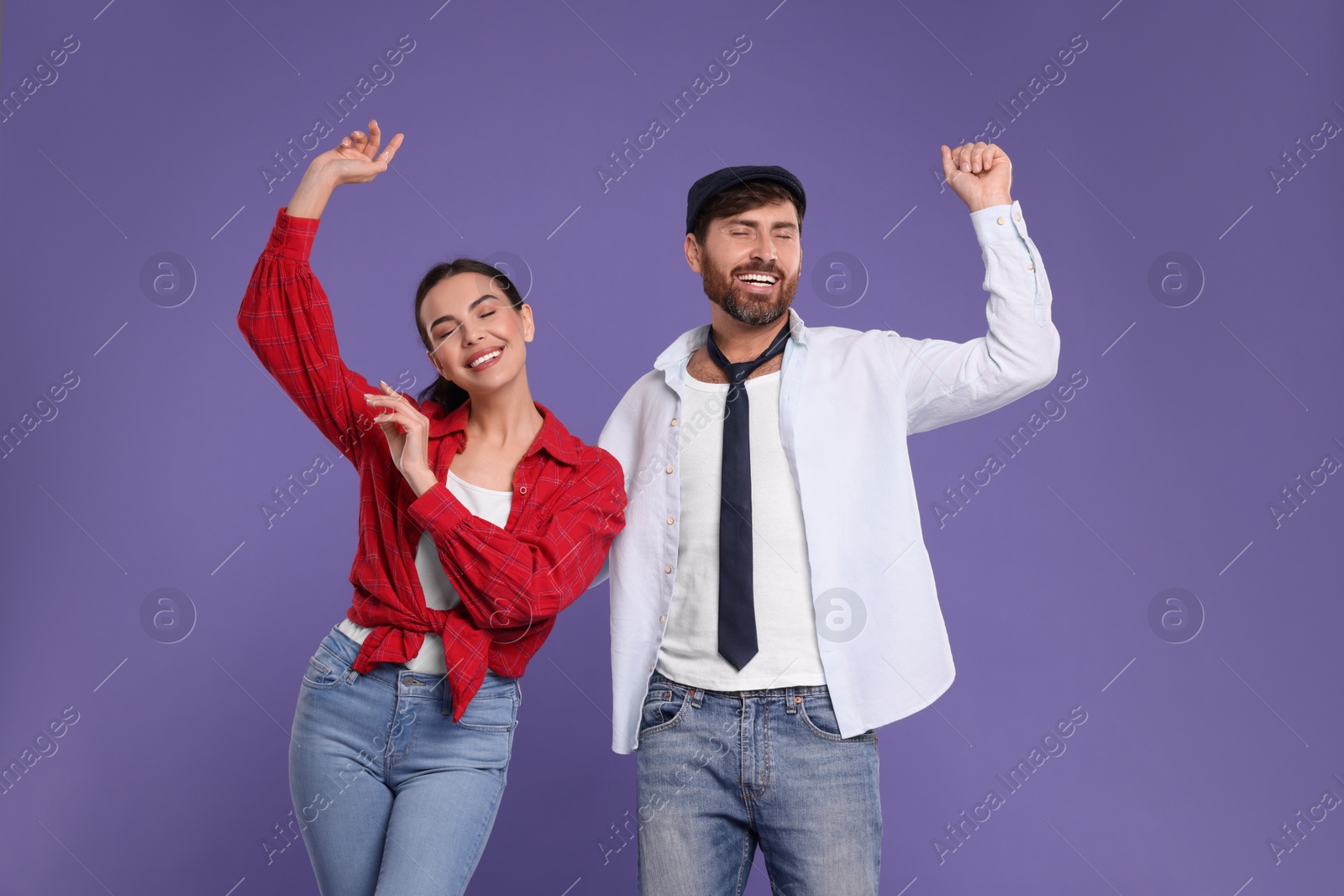 Photo of Happy couple dancing together on violet background