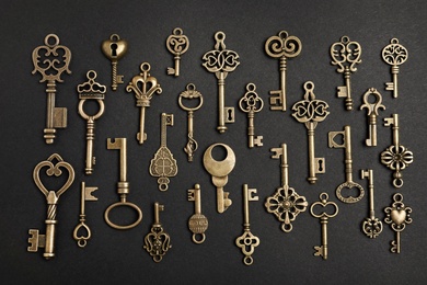 Photo of Flat lay composition with bronze vintage ornate keys on dark background