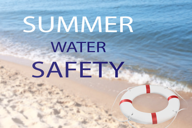 Summer water safety. Life buoy on sandy beach near sea 