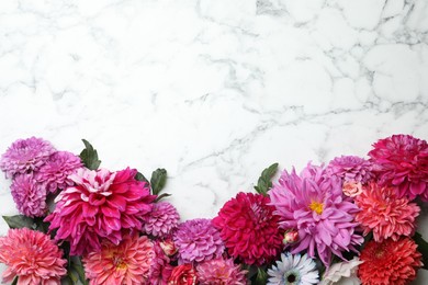 Flat lay composition with beautiful dahlia flowers on white marble background. Space for text