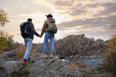 Photo of Couple of hikers enjoying beautiful view near mountain river, back view