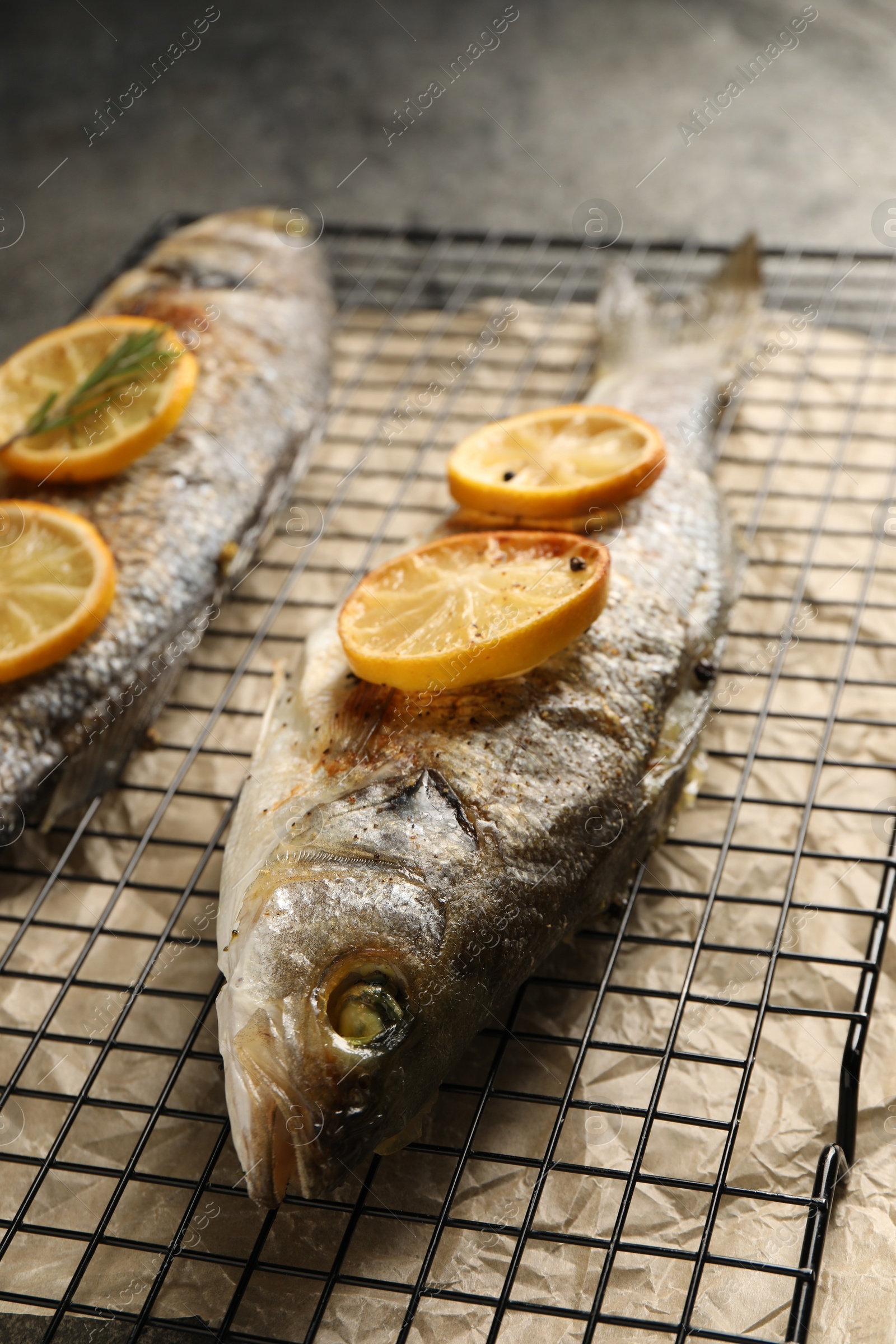 Photo of Baked fish with lemon on cooling rack, closeup