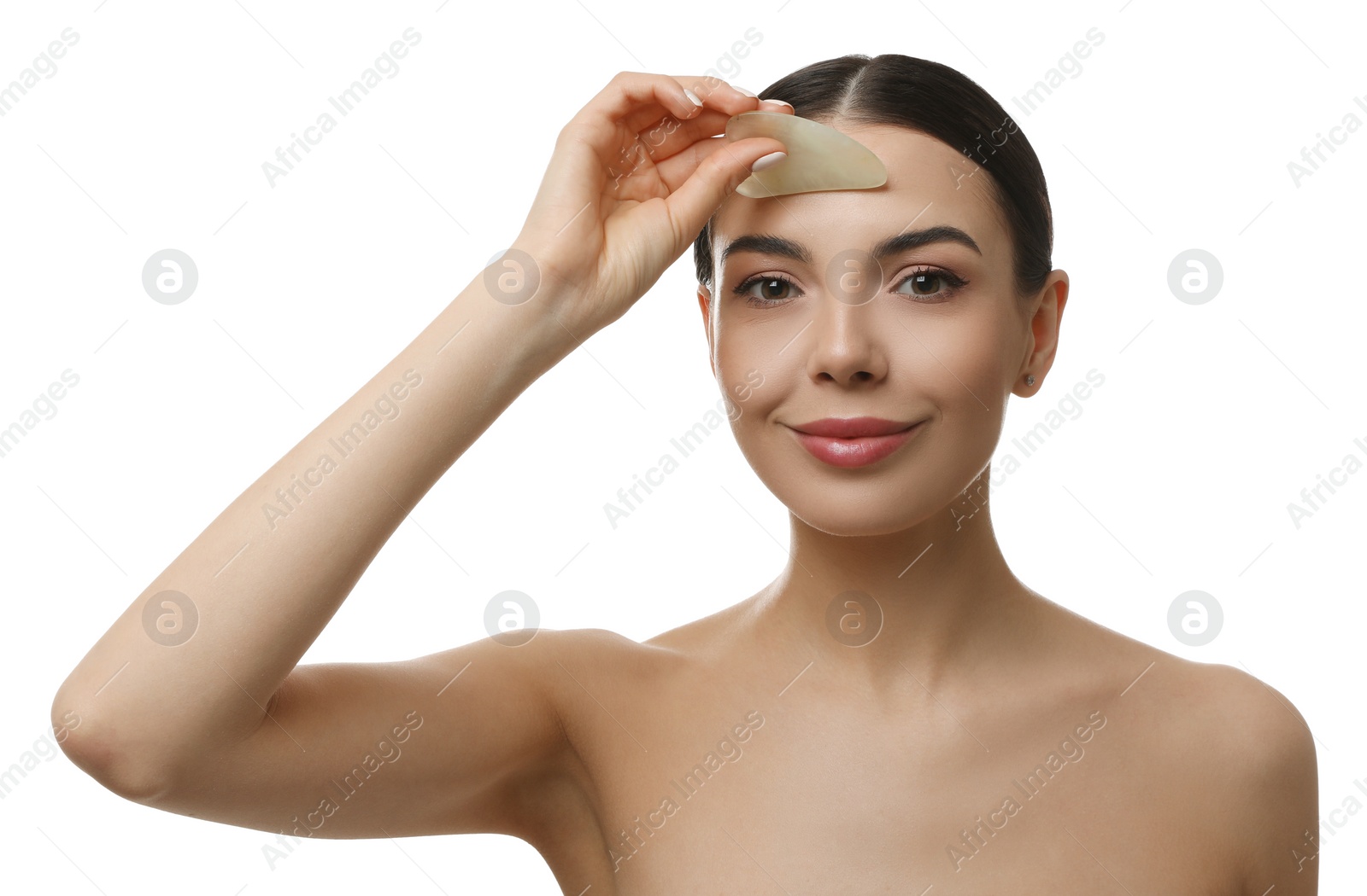 Photo of Beautiful young woman doing facial massage with gua sha tool on white background