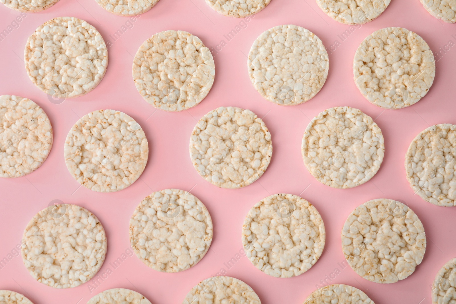 Photo of Puffed rice cakes on pink background, flat lay