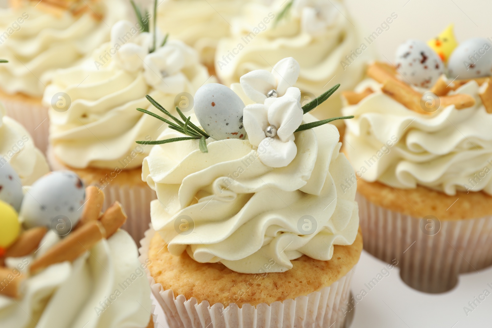 Photo of Tasty Easter cupcakes with vanilla cream in box, closeup