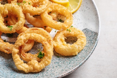 Photo of Homemade crunchy fried onion rings on plate, closeup