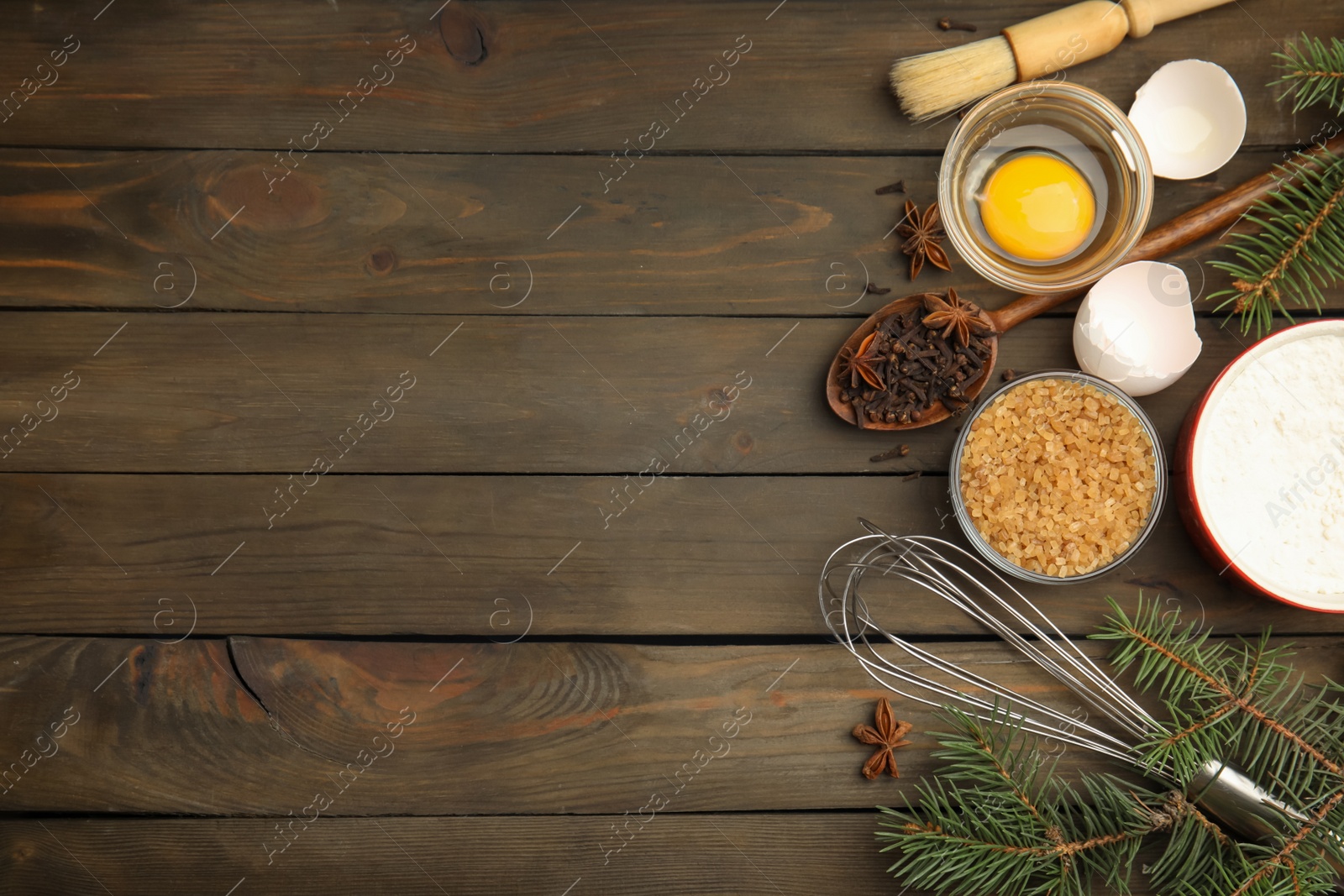 Photo of Flat lay composition with ingredients for traditional Christmas cake on wooden table. Space for text