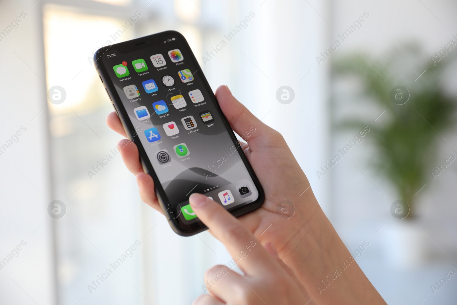 Photo of MYKOLAIV, UKRAINE - MARCH 16, 2020: Woman holding iPhone 11 with home screen indoors, closeup