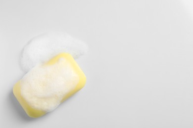 Photo of Soap and fluffy foam on white background, top view