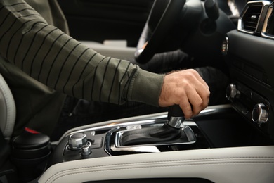 Photo of Man shifting gears in car, closeup. Driving license test